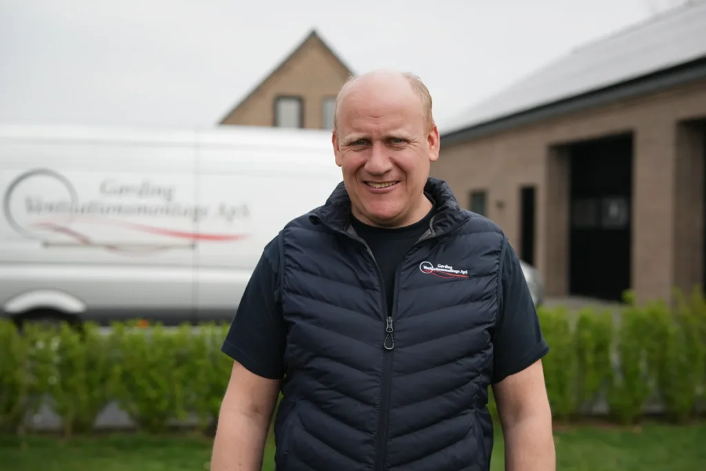 Montør i firmavest foran servicevogn ved Gørding Ventilation adresse, klar til ventilationsservice og filterbestilling
